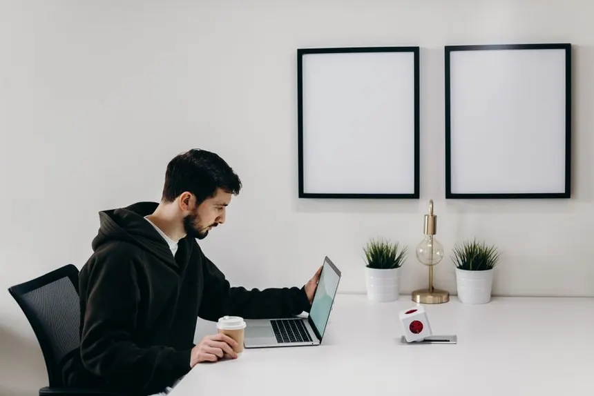 Calm minimal home desk setup with a laptop and coffee, representing a daily focus routine